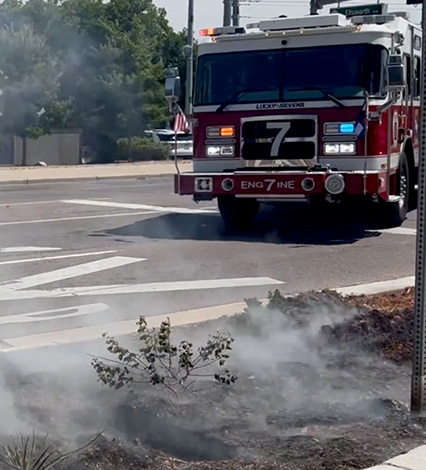 Fire truck in background responding to brush fire in foreground