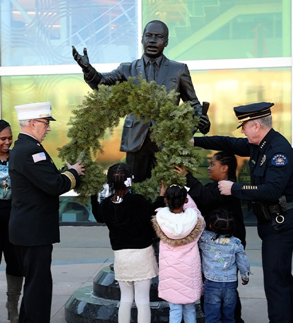 Aurora police chief and community members around MLK Statue on Colfax