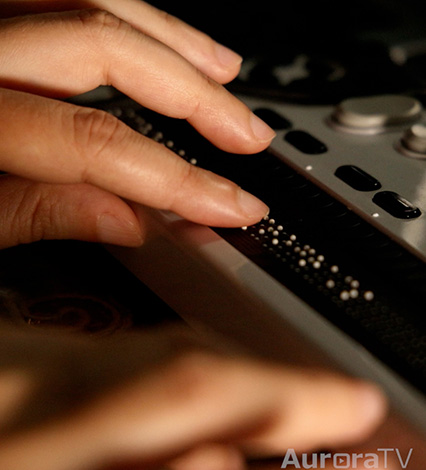 woman's fingers using brail keyboard