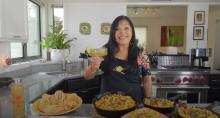 Lindita smiling with Mexican Mac and cheese and drink