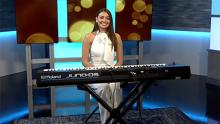 Miss Aurora 2024 smiling in front of piano