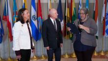 Three people standing in front of international flags that links to a video Proclamation for Constitution week 2024.