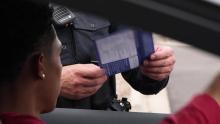 Officer talking to someone through a window with envelope in hand