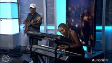 piano player in AuroraTV studio with guitarist in background