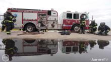 Aurora fire truck and firefighters next to a giant puddle of water