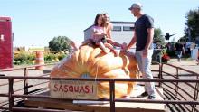 Brad Bledsoe and daughters sitting on giant pumpkin named "Sasquash"