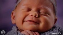newborn wrapped in blanket smiling