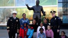 police chief, deputy fire chief and kids pose with mlk statue