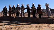 group wearing cowboy hats shoveling dirt at groundbreaking