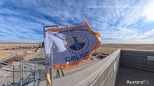 police flag waving on top of building with blue sky and clouds in background