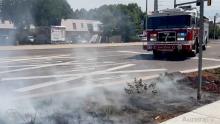 Fire truck in background responding to brush fire in foreground