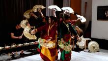 group of Filipino women dancers holding gold fans and forming a circle