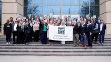 Mayor Coffman and dozens of advocates hold Donate Life banner and signs on Aurora Municipal Center steps