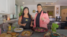 Lindita and individual dressed up as Elvis cooking